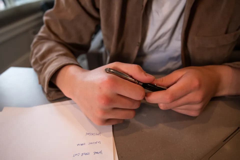 Hands with a pen over paperwork on a desk